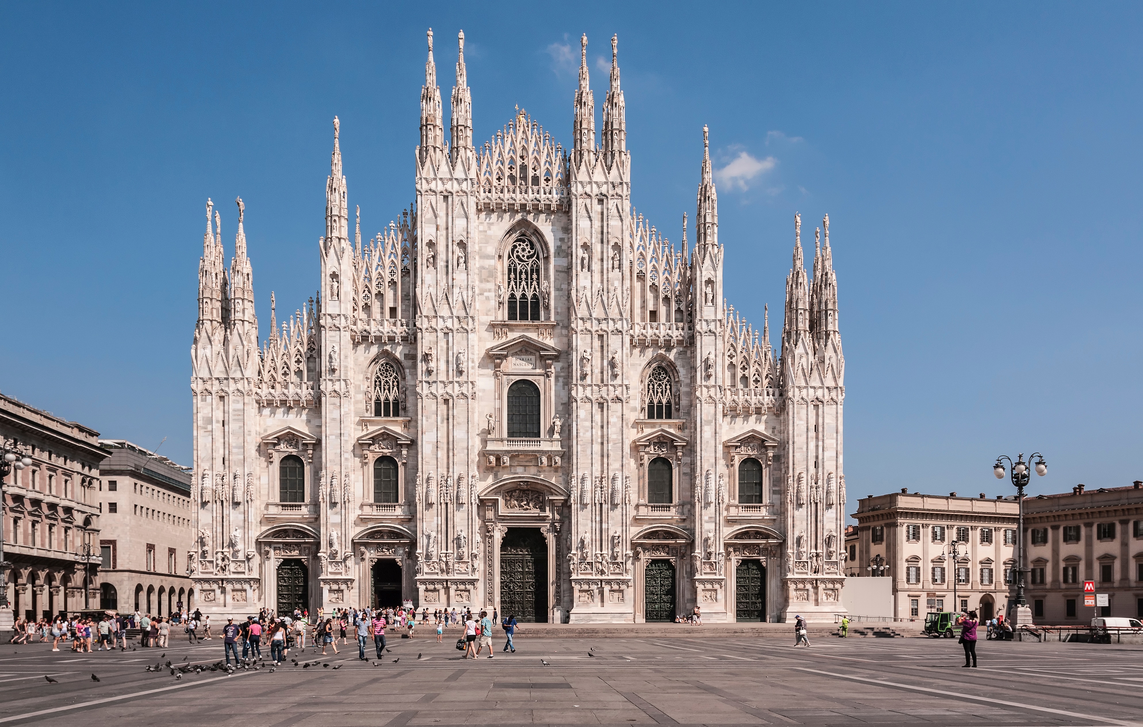 The majestic Milan Duomo Cathedral in Milan, Italy, showing its intricate Gothic facade and spires under a clear sky.